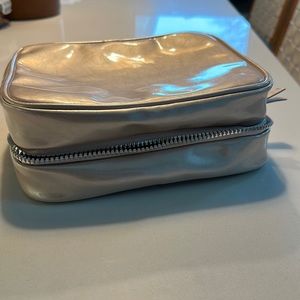 Light pink metallic makeup case. Good for travel, side pockets with zippers